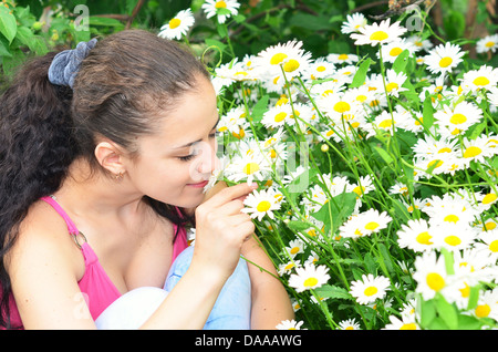 young beautiful woman smelling camomiles Stock Photo