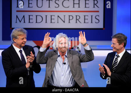 British enterpriser and billionaire Richard Branson is awarded with the German Media Prize 2010 at the Congress Center of Baden Baden, Germany, 24 January 2011. Despite his cruciate ligament rupture, he showed up on crutches to receive his prize. To his left stands media entrepreneur Karlheinz Koegel, to his right German Foreign Minister Guido Westerwelle, who held the laudation. S Stock Photo