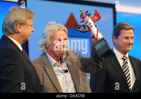 British enterpriser and billionaire Richard Branson is awarded with the German Media Prize 2010 at the Congress Center of Baden Baden, Germany, 24 January 2011. Despite his cruciate ligament rupture, he showed up on crutches to receive his prize. To his left stands media entrepreneur Karlheinz Koegel who founded the prize, to his right German Foreign Minister Guido Westerwelle, who Stock Photo