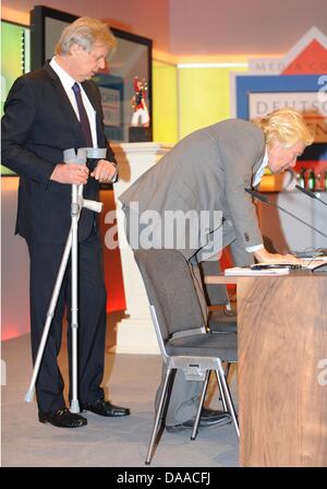 British enterpriser and billionaire Richard Branson (r)arrives for the award ceremony of the German Media Prize 2010 together with Karlheinz Koegel (l)at the Congress Center of Baden Baden, Germany, 24 January 2011. Despite his cruciate ligament rupture, he showed up on crutches to receive his prize. Since 1992, the German Media Prize is awarded to a public figure, who has, accordi Stock Photo