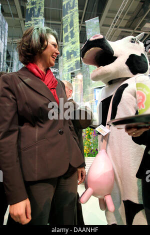 German Agriculture Minister Ilse Aigner is pictured with a person costumed as cow at the Federal-State-Hall at the International Green Week in Berlin, Germany, 20 January 2011. The world's biggest agricultural fair takes place between 21 an 30 January 2011. Photo: Wolfgang Kumm Stock Photo