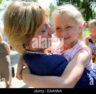 Keila, Estonia, 09 July 2013. Partner of the German President Daniela Schadt holds a child during a visit to the SOS Children's Village in Keila, Estonia, 09 July 2013. Photo: WOLFGANG KUMM/dpa/Alamy Live News Stock Photo