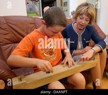 Keila, Estonia, 09 July 2013. Partner of the German President Daniela Schadt visits an SOS Children's Village and learnd how to play a 'Kannel' in Keila, Estonia, 09 July 2013. Photo: WOLFGANG KUMM/dpa/Alamy Live News Stock Photo