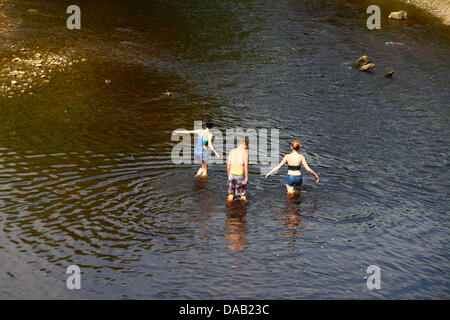 People paddling in the River Wharfe at Ilkley Stock Photo