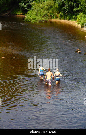 People paddling in the River Wharfe at Ilkley Stock Photo