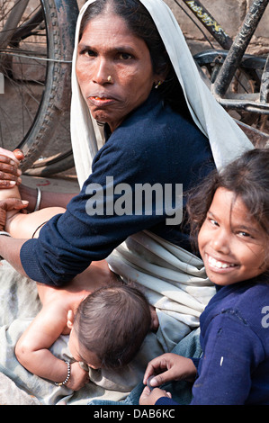 Mother giving oil massage to her baby with her other daughters around ...