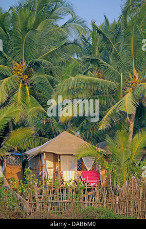 Cocohut beach holiday bungalows on stilts Agonda beach, Goa India Stock Photo