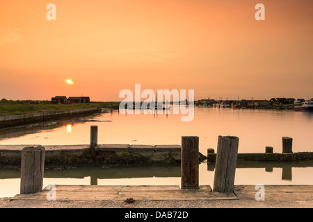 The sun sets over the small harbour at Blackshore, Walberswick in Suffolk. Stock Photo