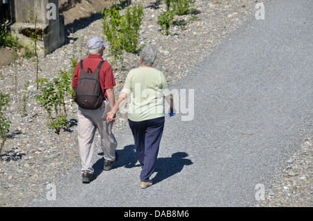 Elderly couple walking along a footpath Stock Photo