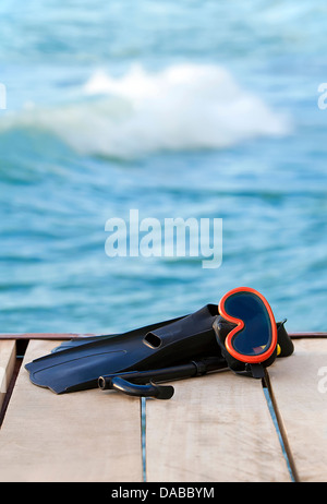A view of diving goggles, swimming fins and snorkel near the lake Stock Photo
