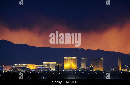 Las Vegas, Nevada, USA. 8th July, 2013. Smoke from the Carpenter 1 wildfire hangs over the Las Vegas Strip as the sun sets over Las Vegas on July 8, 2013. The National Interagency Fire Center said the Carpenter 1 fire remains the highest ranked priority fire in the nation as it consumed slightly more than 5 percent of the Spring Mountain range and threatens more than 400 structures. Credit:  David Becker/ZUMAPRESS.com/Alamy Live News Stock Photo