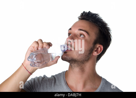 Fit and handsome young man drinking water from plastic bottle, isolated on white Stock Photo