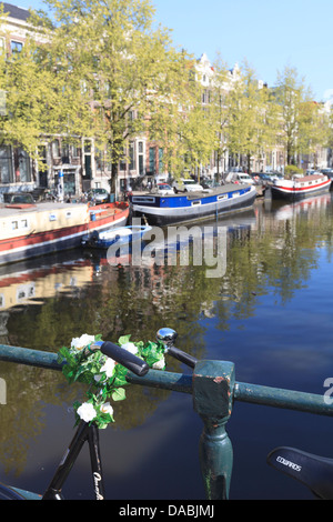 A bicycle decorated with flowers by a canal, Amsterdam, Netherlands, Europe Stock Photo