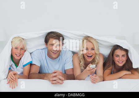 Cheerful family hiding under the blanket Stock Photo