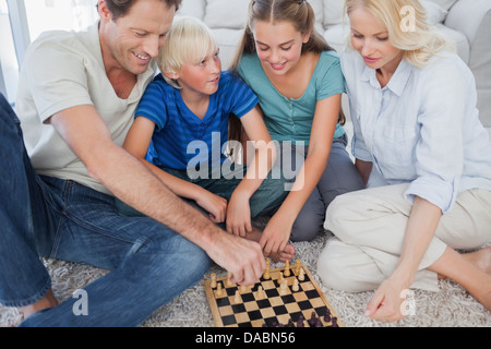 Portrait of a cheerful family playing chess Stock Photo