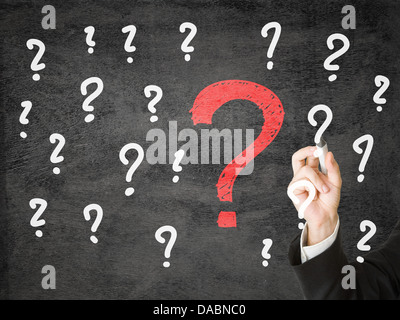 Businessman drawing question marks on transparent display Stock Photo