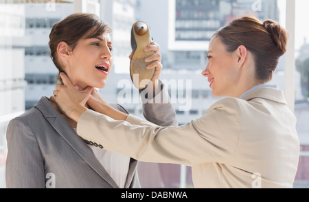 Businesswoman defending herself from her colleague strangling her Stock Photo