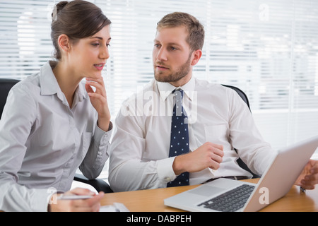 Business people discussing something on laptop Stock Photo