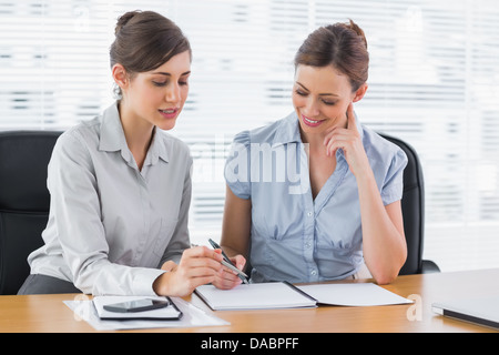 Happy businesswomen working together on documents Stock Photo