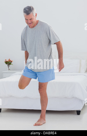Mature man stretching his leg Stock Photo