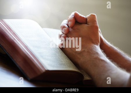 Praying hands on a Holy Bible Stock Photo