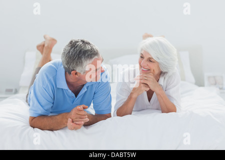 Couple lying and talking together in bed Stock Photo