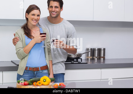 Delighted couple clinking their glasses of red wine Stock Photo