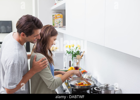 Man looking at his wife cooking Stock Photo