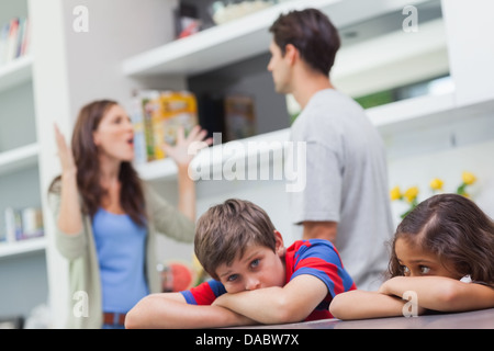 Couple arguing behind their children Stock Photo