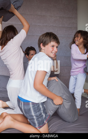 Happy family having a pillow fight on the bed Stock Photo