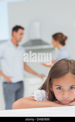Little girl being sad while parents are quarreling Stock Photo