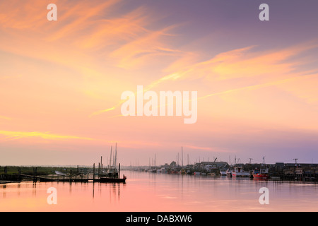 The sun sets over the estuary and small harbour at Blackshore, Walberswick in Suffolk. Stock Photo