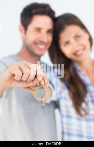 Man and wife presenting a key with a house keychain Stock Photo