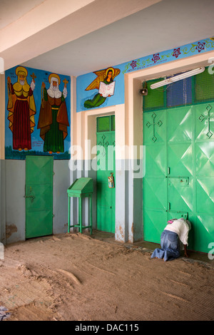 Africa, Eritrea, Massawa, Tualud, St Mary’s Cathedral Church, woman praying outside closed door Stock Photo