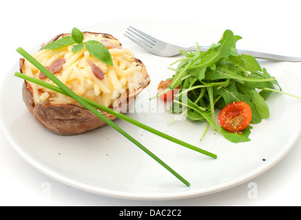 Oven baked jacket potato on a plate with salad and chives Stock Photo