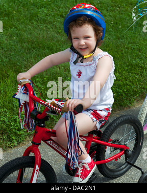 Toddler Girl riding bicycle in Fourth of July parade Stock Photo