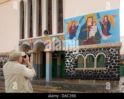 Africa, Eritrea, Massawa, Tualud, St Mary’s Cathedral Church tourist photographing Virgin Mary painted mural Stock Photo