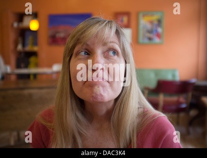 Woman looking up to her left with a smile and lips sealed. Stock Photo