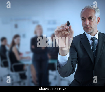 Businessman holding a marker and writing something Stock Photo