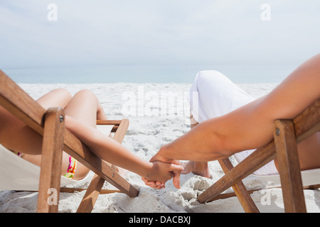 Couple resting on deck chairs Stock Photo