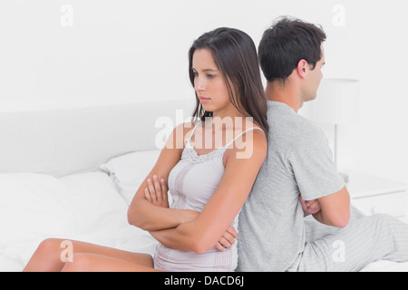 Unhappy couple ignoring each other sitting back to back Stock Photo