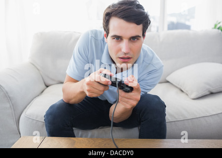 Man having fun with video games while he is sat on a sofa Stock Photo
