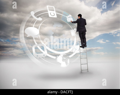Businessman on a ladder touching at a hologram Stock Photo