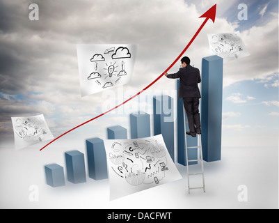 Businessman drawing a red arrow over a chart Stock Photo