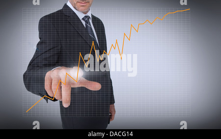 Businessman touching an orange curve Stock Photo