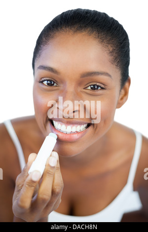 Woman putting lip balm on her lips Stock Photo