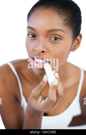 Pretty woman putting lip balm on her lips Stock Photo