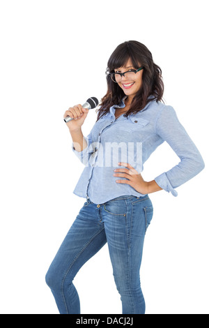 Smiling brunette with her hand on hip singing Stock Photo