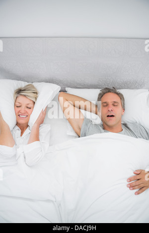 Woman blocking her ears because of partners snoring Stock Photo