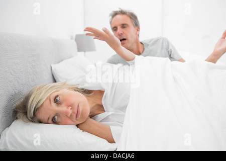 Woman refusing to listen to partner during a fight in bed Stock Photo